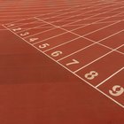 Une piste d'athlétisme rouge, les numéros des couloirs peints sur la ligne de départ